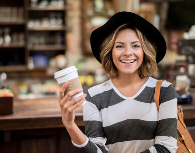 Glad kvinde med coffee to go