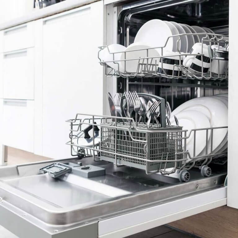 Opvaskemaskine med åben låge i hvidt køkken